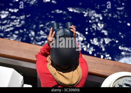 19 août 2019 - en mer - Un membre d'équipage à bord du Coast Guard Cutter Kimball (WMSL 756) monte sa montre d'observation sur l'aile de pont tribord dans un équipement flash et un casque balistique alors que le navire se prépare à tirer son canon Mk-110 57 mm pour la première fois le 19 août 2019. Le navire, le septième National Security Cutter à être acquis par la Garde côtière, est prévu pour une cérémonie unique de double mise en service avec Coast Guard Cutter Midgett (WMSL 757), le huitième NSC, au nouveau port d’attache de cuttersâ€™ à Honolulu le 24 août 2019. (Crédit image : © U.S. Coast Guard/ZUMA Wire/ZUMAPRESS.com) Banque D'Images