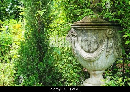 Magnifique sculpture de vase romain en pierre ancienne dans un jardin Banque D'Images