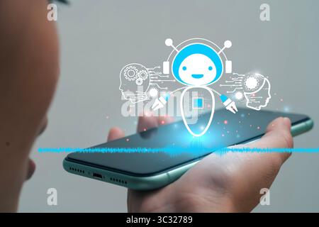 Une personne parlant à un smartphone avec un hologramme d'un chatbot ai mignon apparaissant, représentant l'assistant vocal, l'intelligence artificielle, la communi intelligente Banque D'Images