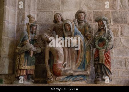 Un groupe sculpté en pierre polychrome de la Lamentation du Christ dans la chapelle de la Pénity jouxtant l'église St Ronan à Locronan, Bretagne, France. Banque D'Images