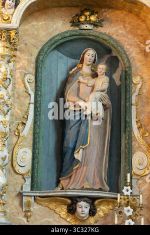 Statue en bois polychrome du XVIIe siècle de la Vierge à l'enfant à gauche du retable dans la chapelle Saint-Michel, Douarnenez, Bretagne, France. Banque D'Images