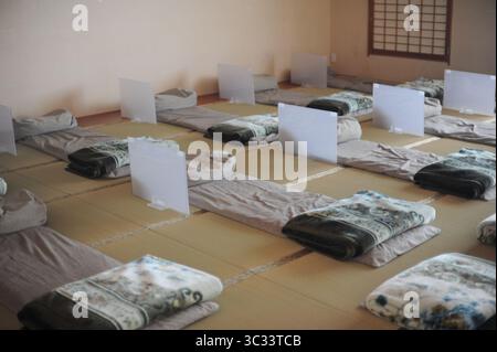 Intérieur d'une chambre d'hôtel traditionnelle au Japon avec matelas futon et oreillers et coussins et tatamis sur un sol Banque D'Images