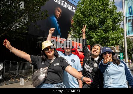Londres, Royaume-Uni. 25 juillet 2025. Des couples de (l) d’Édimbourg (£200/billet) et du Mexique (£400/billet) posant à côté d’une murale Adidas montrant Noel Gallagher et Liam Gallagher (caché par l’arbre) avant le concert Oasis de ce soir au stade de Wembley, la première fois que le groupe joue dans la capitale depuis 16 ans. Le groupe jouera sept dates de juillet à septembre au stade de Wembley dans le cadre de leur Live ’25 Tour, avec le dernier concert le 28 septembre. Credit : Stephen Chung / Alamy Live News Banque D'Images