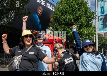 Londres, Royaume-Uni. 25 juillet 2025. Des couples de (l) d’Édimbourg (£200/billet) et du Mexique (£400/billet) posant à côté d’une murale Adidas montrant Noel Gallagher et Liam Gallagher (caché par l’arbre) avant le concert Oasis de ce soir au stade de Wembley, la première fois que le groupe joue dans la capitale depuis 16 ans. Le groupe jouera sept dates de juillet à septembre au stade de Wembley dans le cadre de leur Live ’25 Tour, avec le dernier concert le 28 septembre. Credit : Stephen Chung / Alamy Live News Banque D'Images