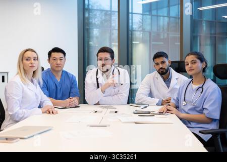 Équipe diversifiée de professionnels de la santé lors d'une réunion par appel vidéo, discutant des soins aux patients Banque D'Images