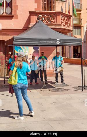 Viladecans. Barcelone - 25 juillet 2025 : capturer l'atmosphère festive d'un concert de rue d'été, avec des interprètes en chemises bleu vif et une histoire Banque D'Images