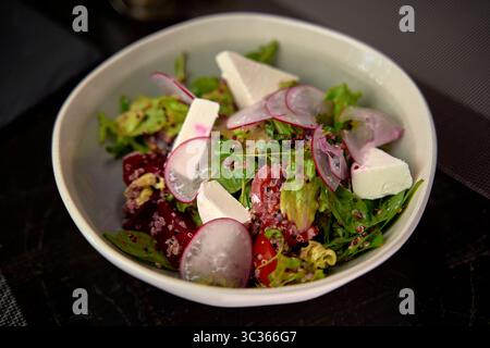 Une salade colorée avec des verts frais, des radis, du fromage feta et du quinoa pour une expérience nutritive et délicieuse Banque D'Images