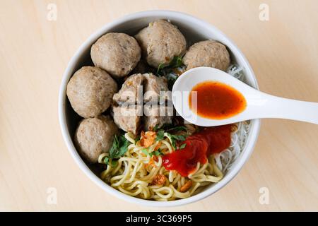 Une vue sur Bakso (également connu sous le nom de Baso), une soupe populaire aux boulettes de viande. Le bouillon est rempli de boulettes de viande de bœuf, de nouilles jaunes, de vermicelles et de piment. Banque D'Images