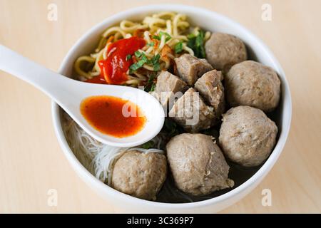Bakso (également connu sous le nom de Baso), une soupe populaire aux boulettes de viande. Le bouillon est rempli de boulettes de viande de bœuf, de nouilles jaunes, de vermicelles et d'une cuillerée de piment. Banque D'Images