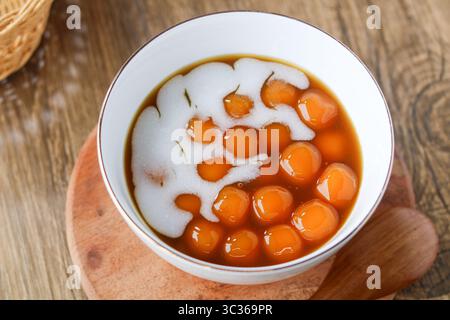 Vue rapprochée d'un bol de salak biji indonésien (patates douces et boules de tapioca dans une sauce au sucre de palme). Banque D'Images