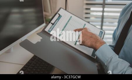 un homme d'affaires est assis dans son bureau privé, un entrepreneur travaille avec diligence, le comptable en chef examine les documents et les chiffres budgétaires Banque D'Images