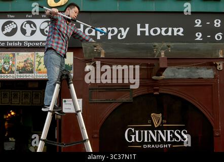 11 avril 2021, PÉKIN, CHINE : un membre du personnel chinois porte un masque de protection pour le visage lors du nettoyage de l'extérieur d'un bar occidental populaire, entièrement ouvert aux affaires, à Pékin le dimanche 11 avril 2021. La capitale chinoise a réduit le port obligatoire de masques de protection, sauf dans les transports en commun, et la distanciation sociale alors que la ville retourne lentement à la vie d’avant covid 19 avec des restaurants, des commerces et des écoles entièrement ouverts. (Crédit image : © Todd Lee/ZUMA Wire) Banque D'Images