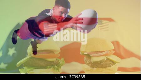 Athlète de plongée portant maillot et short sautant en studio, avec football, hamburgers, drapeau américain Banque D'Images