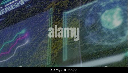 Affichage de la superposition numérique flottant au-dessus de la canopée de la forêt avec des panneaux, des graphiques, HUD et du texte alphanumérique Banque D'Images