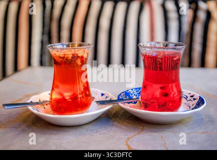 Verre traditionnel en forme de tulipe de mûrier turc et thé aux pommes ou chai servi dans des verres en forme de tulipe dans un restaurant, Istanbul, Turquie Banque D'Images