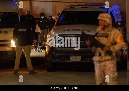 Les autorités médico-légales sondent une scène de crime nocturne près de Ciudad Juarez, un point chaud pour les conflits frontaliers et les problèmes de migration, dans des conditions de sécurité strictes. Banque D'Images