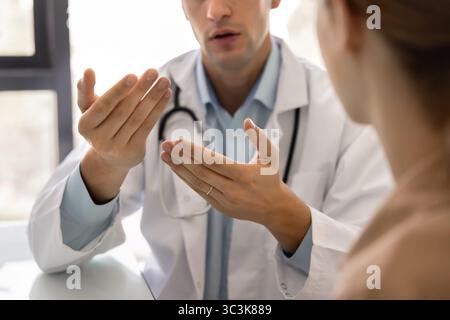 Plan recadré d'un jeune médecin sérieux parlant à un patient Banque D'Images