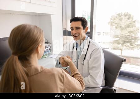 Heureux jeune docteur hispanique donnant la poignée de main de salutation Banque D'Images