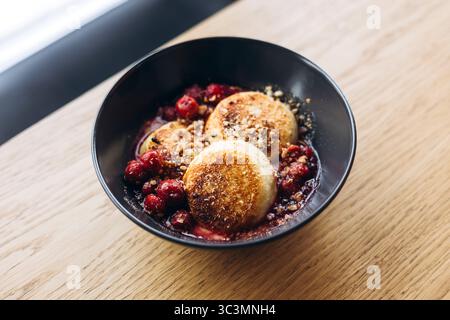 D'en haut délectez-vous de cheesecakes fraîchement servis dans un café confortable, parfait pour un petit déjeuner. Ces cheesecakes sont garnis de baies et de noix Banque D'Images