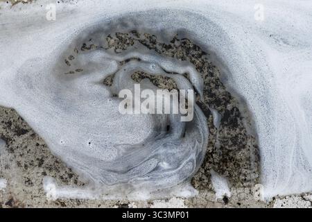 Image en gros plan de savon mousseux tourbillonnant sur une surface de voiture, mettant en évidence la texture et les motifs créés pendant le processus de nettoyage, mettant en évidence le nettoyage Banque D'Images