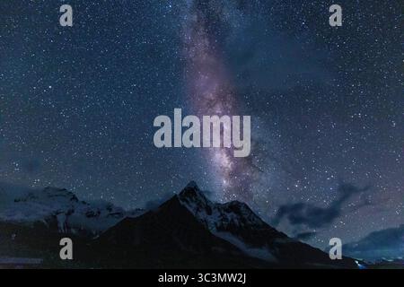 La voie Lactée illumine le ciel nocturne au-dessus des sommets himalayens, créant une vue époustouflante. Les montagnes enneigées se dressent contre le Banque D'Images