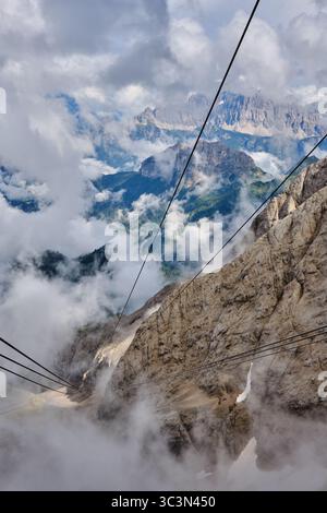 Le téléphérique Malga Ciapela de Seratua, le premier arrêt sur la route vers le sommet de la Marmolada dans les Dolomites avec des montagnes entourées de nuages. Banque D'Images