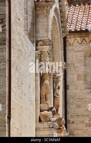 122 Collegiata dei Santi Quirico e Giulitta Eglise, portail latéral roman-gothique flanqué de deux caryatides reposant sur des lions. San Quirico d'Orcia-Italie Banque D'Images