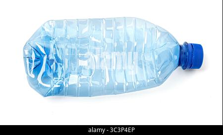 Plan studio d'une bouteille d'eau en plastique écrasée vide avec bouchon bleu, isolée sur fond blanc, représentant le recyclage et les questions environnementales Banque D'Images