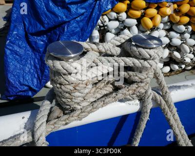 Taquet d'amarrage attaché avec une corde sur le côté du bateau de pêche commerciale avec filet et flotteurs Banque D'Images