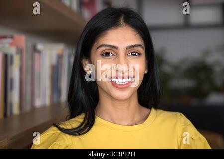 Gros plan portrait d'une étudiante heureuse debout seule dans la bibliothèque Banque D'Images