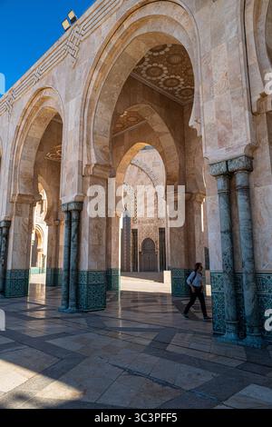 Casablanca, Maroc, 27 mars 2025. Un touriste se promène parmi les arches de la mosquée Hassan II Banque D'Images