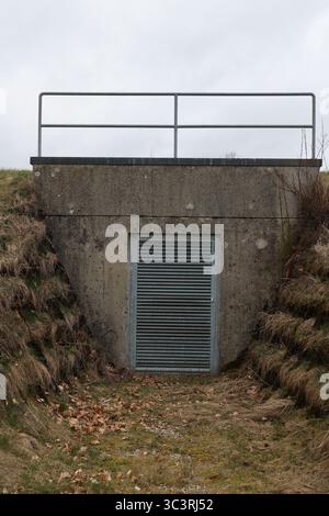 Un petit tunnel étroit avec une porte de grille métallique Banque D'Images