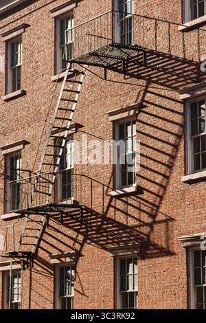 Ombres de la sortie de secours sur une façade en briques Banque D'Images