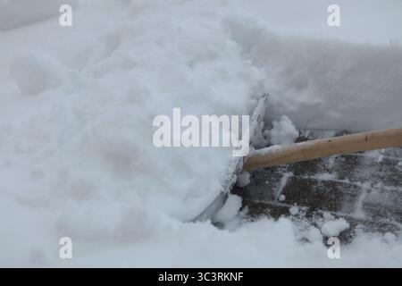 La pelle à neige est utilisée pour déneiger un trottoir Banque D'Images