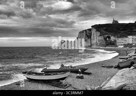 Bateaux couchés sur la plage, plage de galets, arche rocheuse falaise ou porte d'amont, église Chapelle notre Dame de la Garde, Etretat, mer, côte escarpée, falaises Banque D'Images