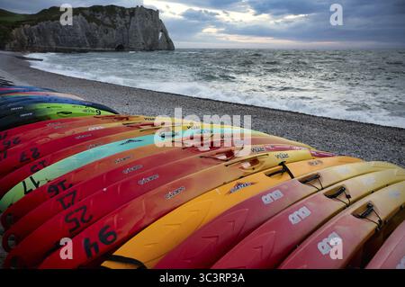 Kayaks, bateaux, colorés, couchés sur la plage, plage de galets, arche rocheuse falaise ou porte d'aval, Etretat, mer, côte escarpée, falaises, falaises de craie, alaba Banque D'Images