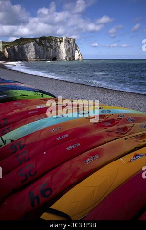 Kayaks, bateaux, colorés, couchés sur la plage, plage de galets, arche rocheuse falaise ou porte d'aval, Etretat, mer, côte escarpée, falaises, falaises de craie, alaba Banque D'Images