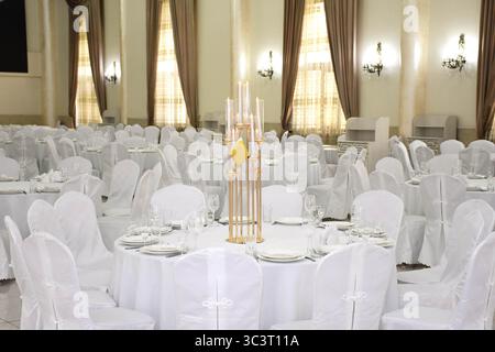 Grande salle de banquet lumineuse spacieuse lors d'un mariage. Salle de banquet de mariage Banque D'Images