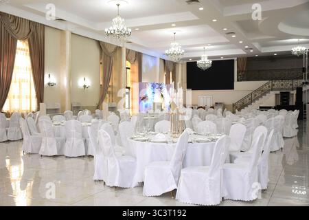 Grande salle de banquet lumineuse spacieuse lors d'un mariage. Salle de banquet de mariage Banque D'Images