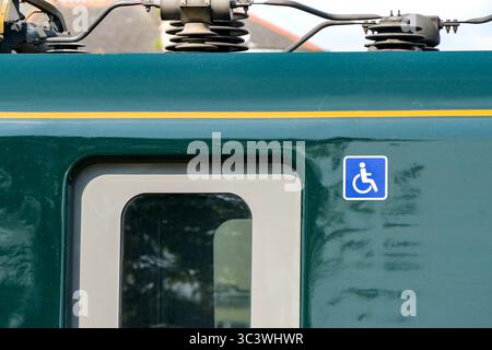 Paignton, Devon, Angleterre, Royaume-Uni - 24 avril 2025 : vue rapprochée du symbole de voiture accessible en fauteuil roulant à côté de la porte d'un wagon de train Banque D'Images