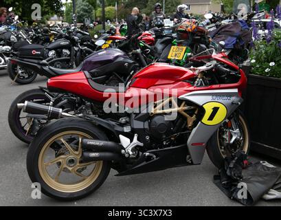 Gros plan d'une MV Agusta Superveloce rouge et or garée parmi d'autres vélos lors du rassemblement moto Calne Bike Meet dans un cadre extérieur Banque D'Images