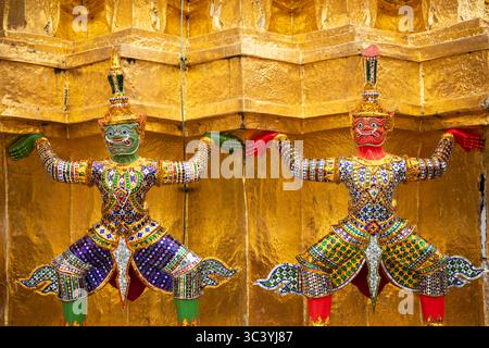 Sculptures de démons Yaksha sur les pagodes dorées à l'extérieur du temple du Bouddha d'émeraude, Wat Phra Kaew dans le Grand Palais Royal, Bangkok, Thaïlande Banque D'Images