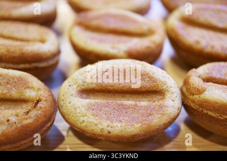 Gros plan sur les appétissants petits gâteaux en forme de haricots de café fraîchement cuits Banque D'Images