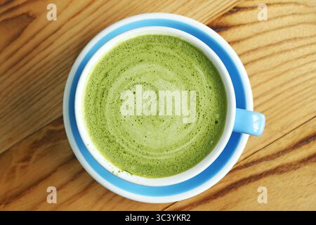 Vue de dessus de Hot Matcha Green Tea Latte isolé sur fond en bois Banque D'Images