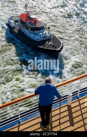 Homme observant le bateau DHB Diligent de la Dover Pilot Harbour Patrol approchant un navire de croisière à Dover, Kent, Royaume-Uni en mai Banque D'Images