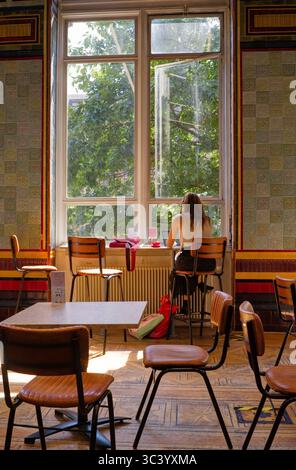 Jeune femme travaillant sur ordinateur portable dans le café de la galerie d'art de Leeds Banque D'Images