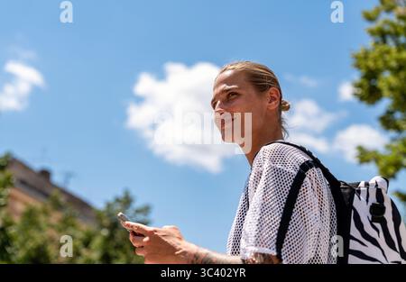 Portrait de jeune femme à la mode tenant smartphone à l'extérieur sur la rue de la ville Banque D'Images