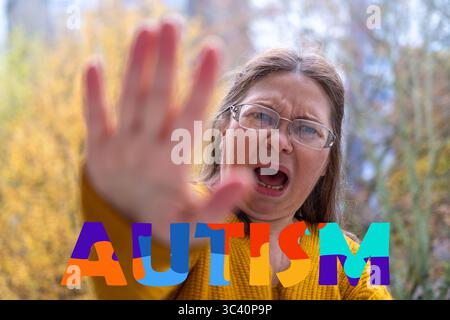 femme tendre la main avec les mains ouvertes, rejetant une menace invisible, journée de sensibilisation à l'autisme, espace personnel, indices non verbaux et besoin de compréhension, wor Banque D'Images