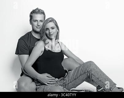 Photo en noir et blanc de jeune couple adulte enceinte attendant le bébé, grossesse heureuse futurs parents ensemble. Horizontalement. Banque D'Images