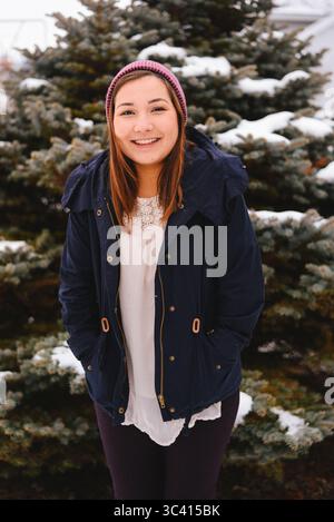 Jeune femme souriante et profitant du pays des merveilles hivernales Banque D'Images